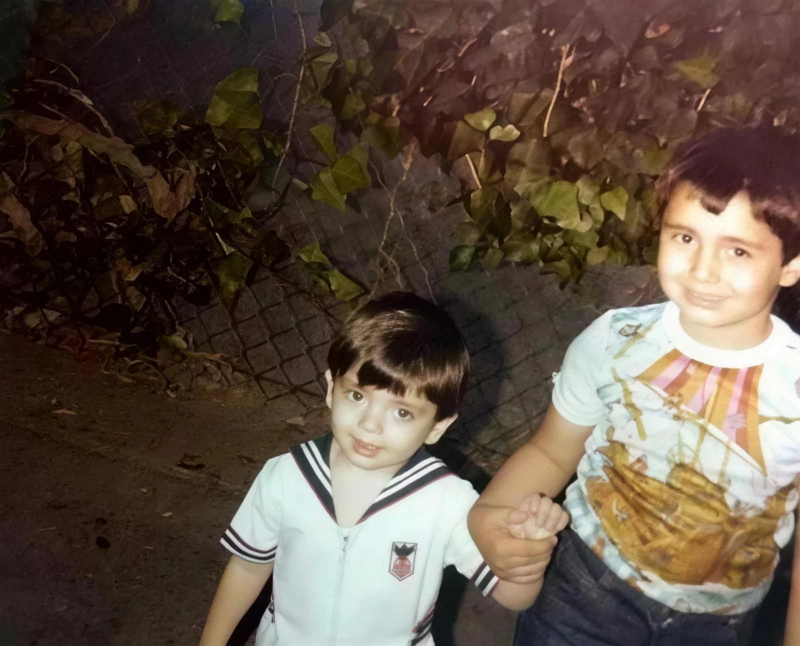 A restored childhood photograph of Sam Mikhail holding his younger brother's hand in Southern California
